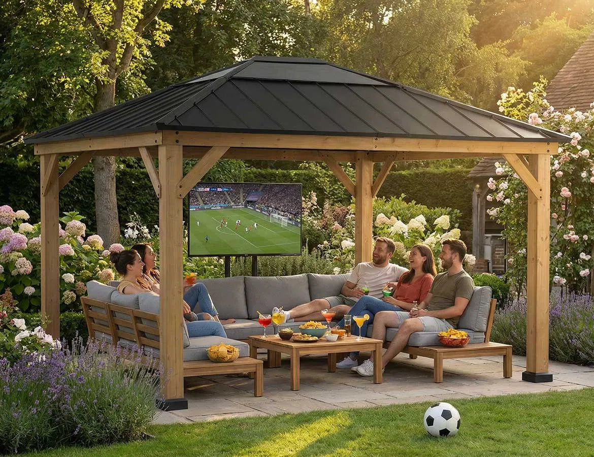 People sitting under a wooden gazebo watching TV in a garden setting.